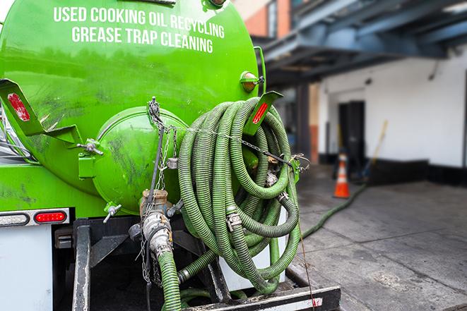 a technician pumping a grease trap in a commercial building in Belvidere